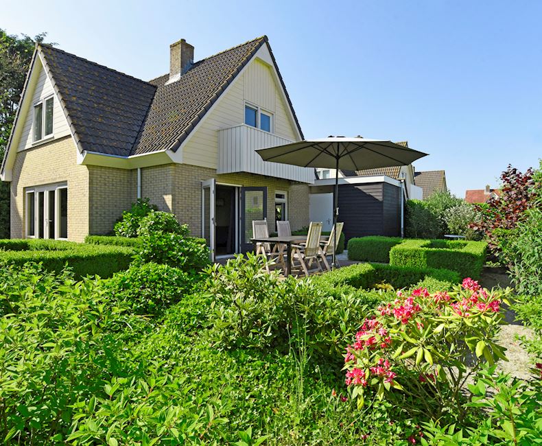 Huisje aan strand met hond op Waddeneiland